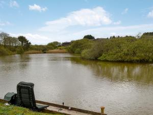 a chair sitting on the side of a river at The Brown House in Woolfardisworthy
