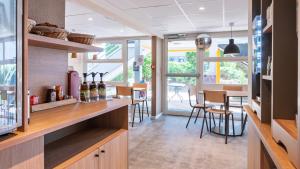 a kitchen with a counter with bottles of wine at Premiere Classe Lille Ouest - Lomme in Lomme +17 photos
