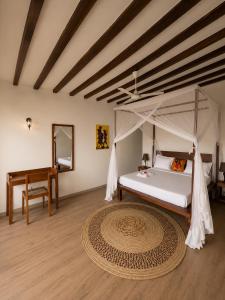 a bedroom with a canopy bed and a rug at Malcom Ocean View Retreat in Pongwe
