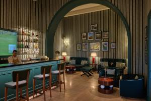 a bar with chairs and a man standing behind it at Verdura Resort in Ribera