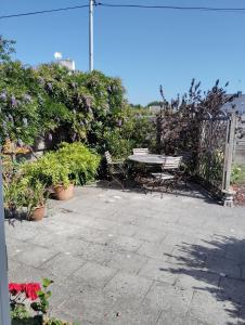 a patio with a table and chairs and plants at Kerlir in Ploemeur