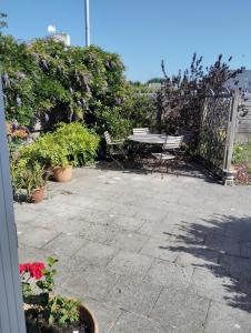 a patio with a table and chairs and plants at Kerlir in Ploemeur