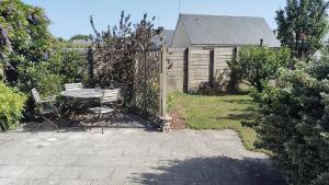 a patio with a table and chairs and a fence at Kerlir in Ploemeur