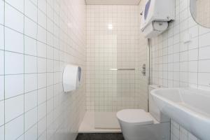 a white tiled bathroom with a toilet and a sink at Salt&Flow in Parede +44 photos