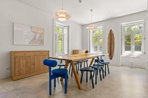 a kitchen with a wooden table and blue chairs at Salt&Flow in Parede