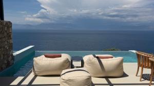 a balcony with chairs and a view of the ocean at ​Le Grand Bleu Resort in Derveni