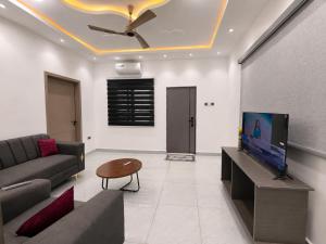 a living room with a couch and a flat screen tv at Maatambaba Homes in Tamale