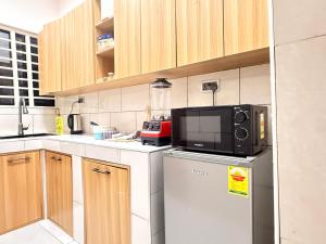 a kitchen with a microwave on top of a refrigerator at Maatambaba Homes in Tamale
