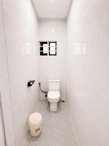 a white bathroom with a toilet and a window at Maatambaba Homes in Tamale