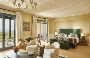 a bedroom with a bed and chairs and a table at Verdura Resort in Ribera +107 photos