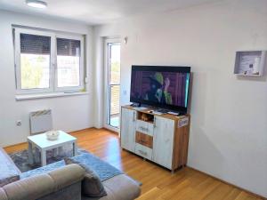 a living room with a couch and a flat screen tv at Apartman 40 in Modriča