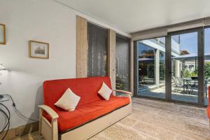 a red couch in a living room with windows at Casa de Férias Da Padroa in Braga