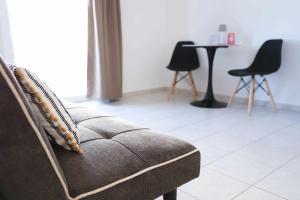 a couch in a living room with two chairs and a table at Apartment Simply 206 in Gázion