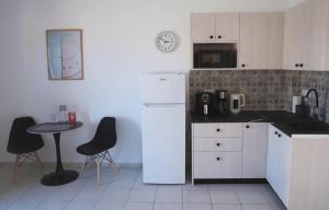 a kitchen with a white refrigerator and a table and chairs at Apartment Simply 206 in Gázion +16 photos