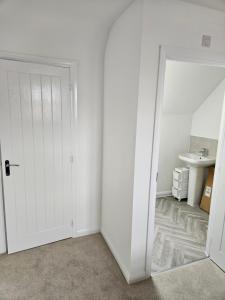 an empty room with a white door and a sink at Hanavine Room in Moulton