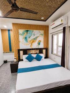 a bedroom with a large white bed with blue pillows at Hotel Radha Rani Bhawan in Vrindāvan +8 photos