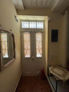 a room with a door with a window and a mirror at Plomari Rum Evi in Plomari