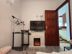 a living room with a fireplace with a tv on top of it at TanúHill Garden in Tapolca