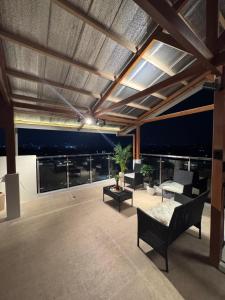 a living room with a couch and chairs on a balcony at Casa Attika - Modern Glasshouse with Skyline Views in Antipolo