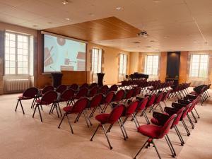 a conference room with red chairs and a screen at Hôtellerie Saint Yves in Chartres