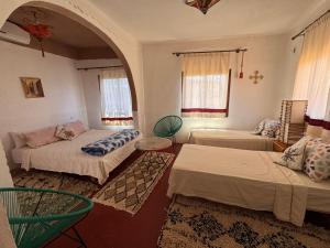 ein Wohnzimmer mit zwei Betten und einer Couch in der Unterkunft Citadelle Gorges in Aït Ben Ali