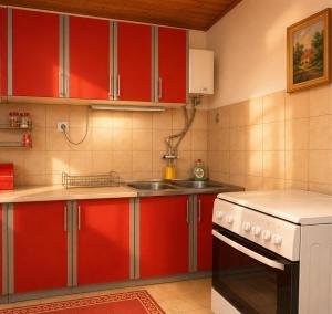 a kitchen with red cabinets and a sink at Apartmani VV in Cetinje