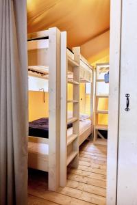 a room with three bunk beds in a room at Glamping Sistiani in Lido di Spina +39 photos