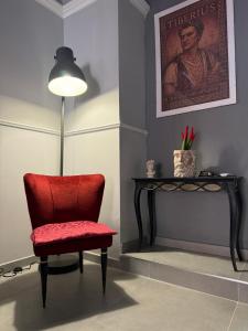 a red chair sitting next to a table with a lamp at CENTURIONI Alloggio turistico in Civitavecchia