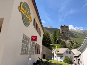 a building with a sign on the side of it at Sust Lodge in Hospental