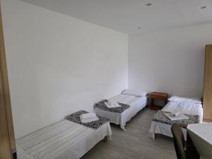 a room with three beds and a table and chairs at PRZYSTANEK nowEKOprzywno in Parchlino