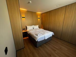 a bedroom with a bed in a room with wooden walls at Alsun Hotel in Astana +93 photos
