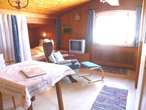 a living room with a bed and a television at Haus Kersting in Reit im Winkl