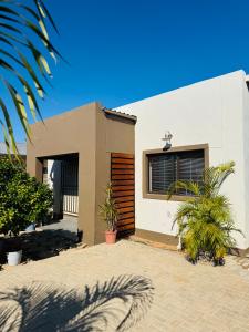 a house with a palm tree in front of it at The Leafy Stay in Rundu