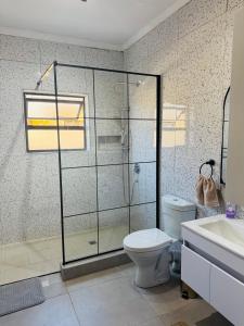 a bathroom with a shower and a toilet and a sink at The Leafy Stay in Rundu +7 photos