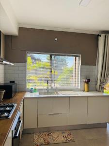 a kitchen with a sink and a window at The Leafy Stay in Rundu