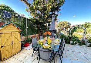 a table with chairs and an umbrella on a patio at Versailles One Garden Villa Full Floor Suite in Koropi