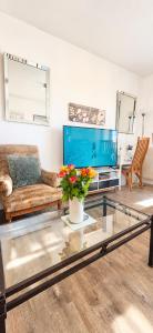 a living room with a couch and a tv at LES FRUITS DE MER, plage et centre à pied, lits faits, parking gratuit, animal bienvenu in Berck-sur-Mer