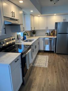 a kitchen with white cabinets and stainless steel appliances at Philly Content House in Marcus Hook +20 photos