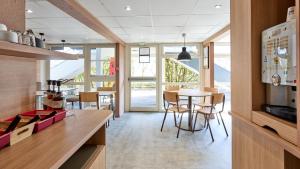 a kitchen and dining room with a table and chairs at Premiere Classe Valenciennes Ouest Petite Foret in Petite Forêt