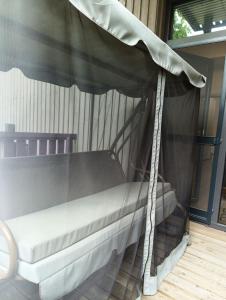 a bed with a canopy on a porch at SOL Apartment in Jūrmala