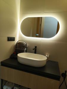 a bathroom with a large white sink on a black counter at SOL Apartment in Jūrmala