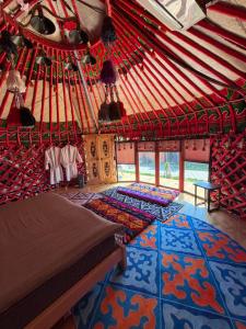 a room with two beds and a rug in a yurt at Bermet guest house in Karakol