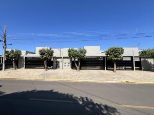 a building with trees in front of a street at Casas Pantanal - Privacidade e conforto no centro de Bonito in Bonito