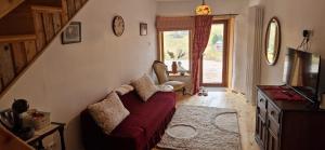 a living room with a red couch and a window at Casuta Letitiei in Şirnea