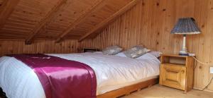 a bedroom with a bed in a wooden room at Casuta Letitiei in Şirnea +10 photos