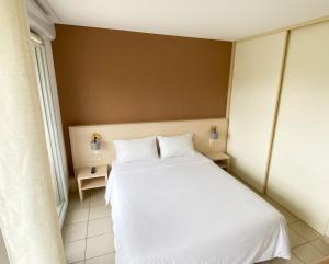 a bedroom with a large white bed with two pillows at Studio climatisé proche du lac in Divonne-les-Bains