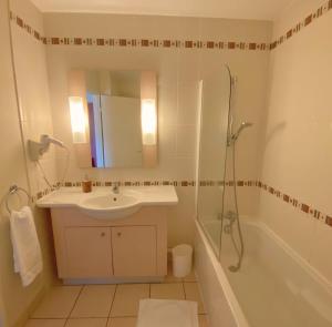 a bathroom with a sink and a shower and a tub at Studio climatisé proche du lac in Divonne-les-Bains