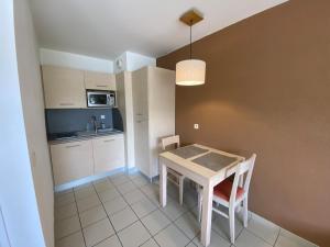 a kitchen and dining room with a table and chairs at Studio climatisé proche du lac in Divonne-les-Bains