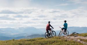 two people riding bikes on top of a hill at Stølsdokken Lodge in Sanderstølen