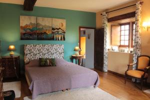 a bedroom with a bed and a painting on the wall at Charmante Demeure 17ème 4ch-3sdb in Bioussac +51 photos